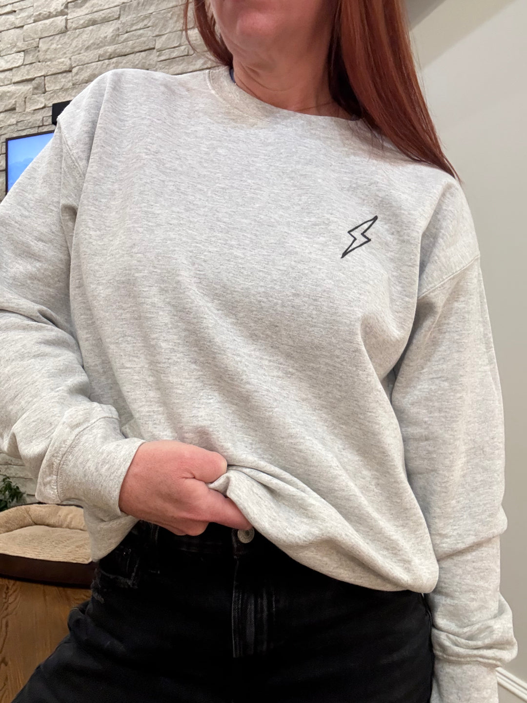 Ladyspinedoc showing the front of the Spinal Strength sweatshirt with lightning bolt logo