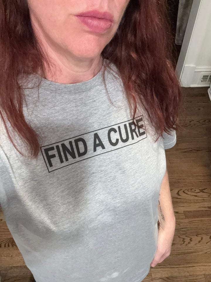 Ladyspinedoc wearing a gray tee with Find A Cure on the front