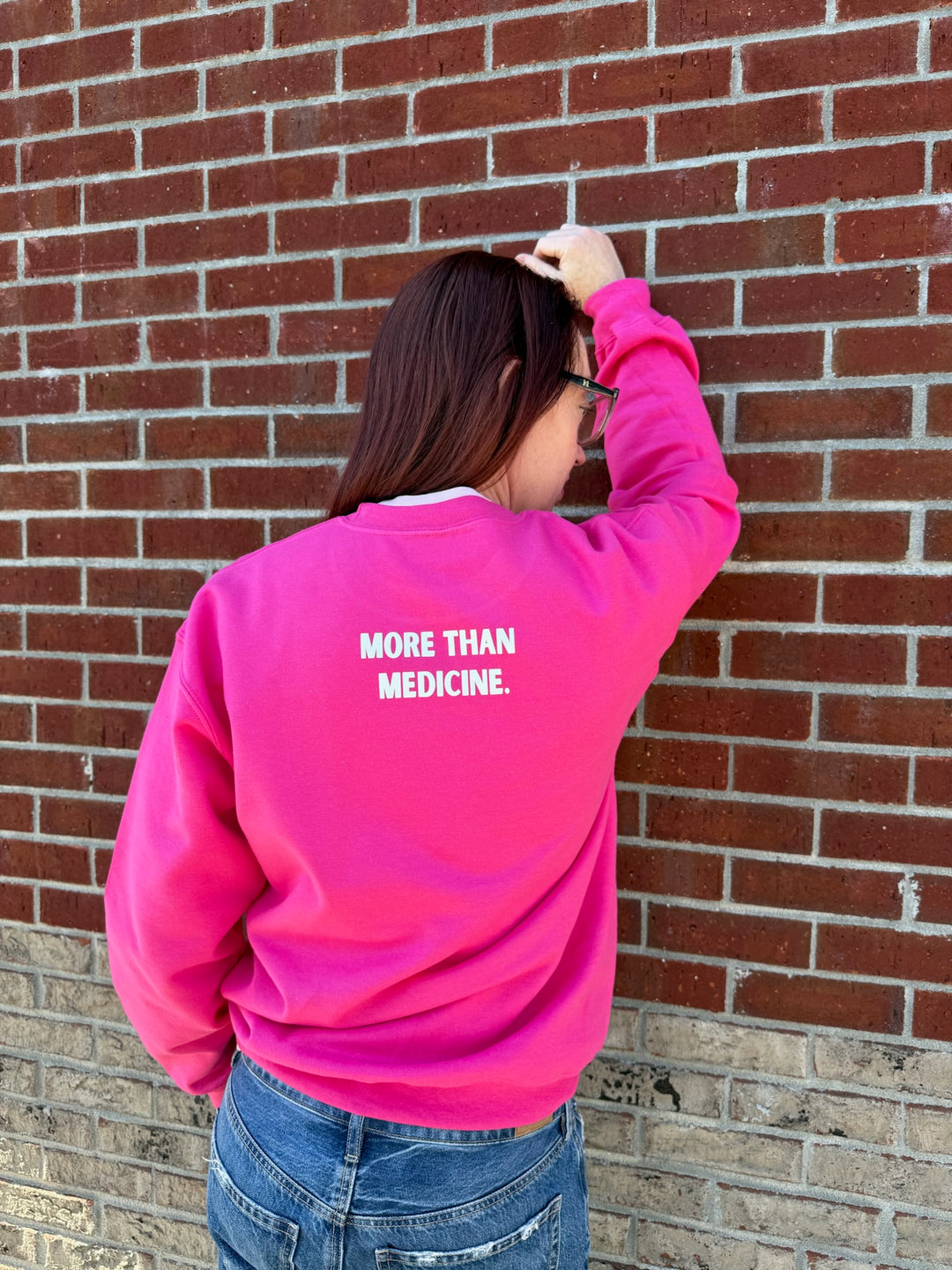 Ladyspinedoc wearing a pink sweatshirt with More Than Medicine printed on the back