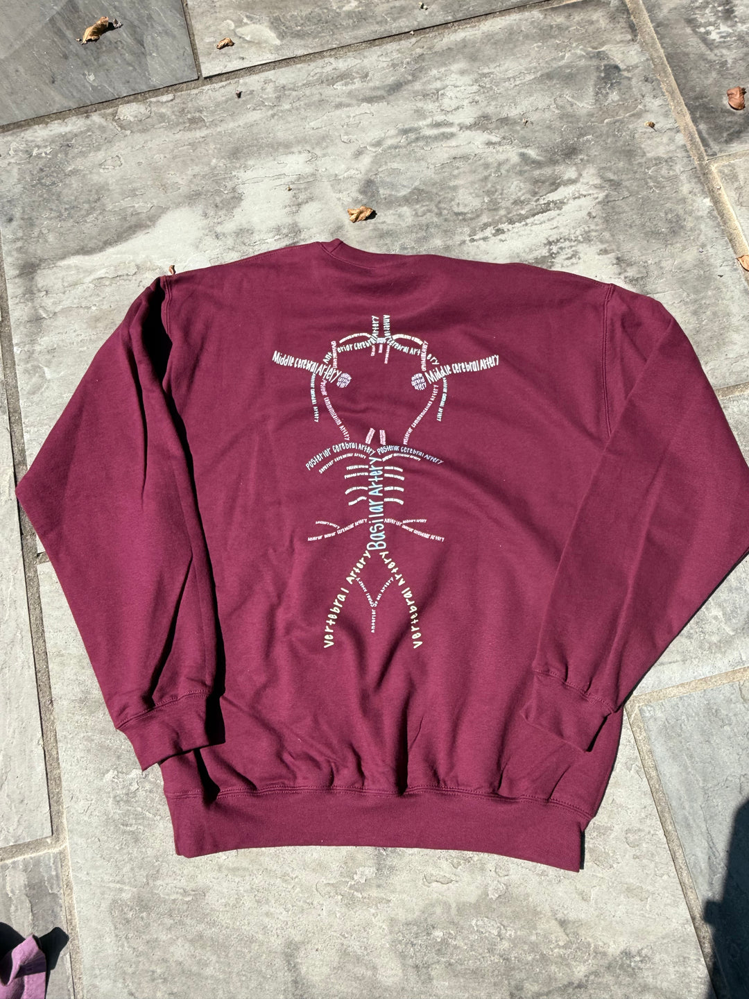 Back of Whatchu Talkin’ About Willis Sweatshirt on stone pavement