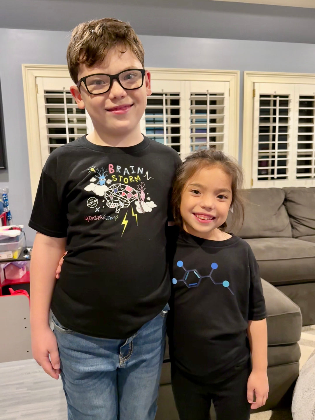 Ladyspinedoc's son wearing the Ladyspinedoc x The Neuron Family - Youth Brain Storm Tee Shirt in Black. Next to him is Ladyspinedoc's daughter wearing the Code Cart Youth tee shirt in black. 