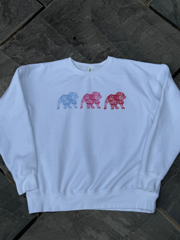 White sweatshirt with bulldog graphics in red, blue, and pink on a dark stone surface