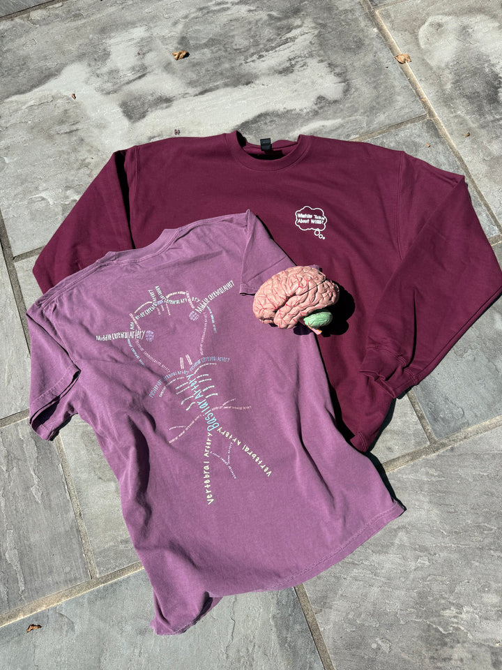 Two Whatchu Talkin’ About Willis shirts on a stone surface, along with an anatomical brain.