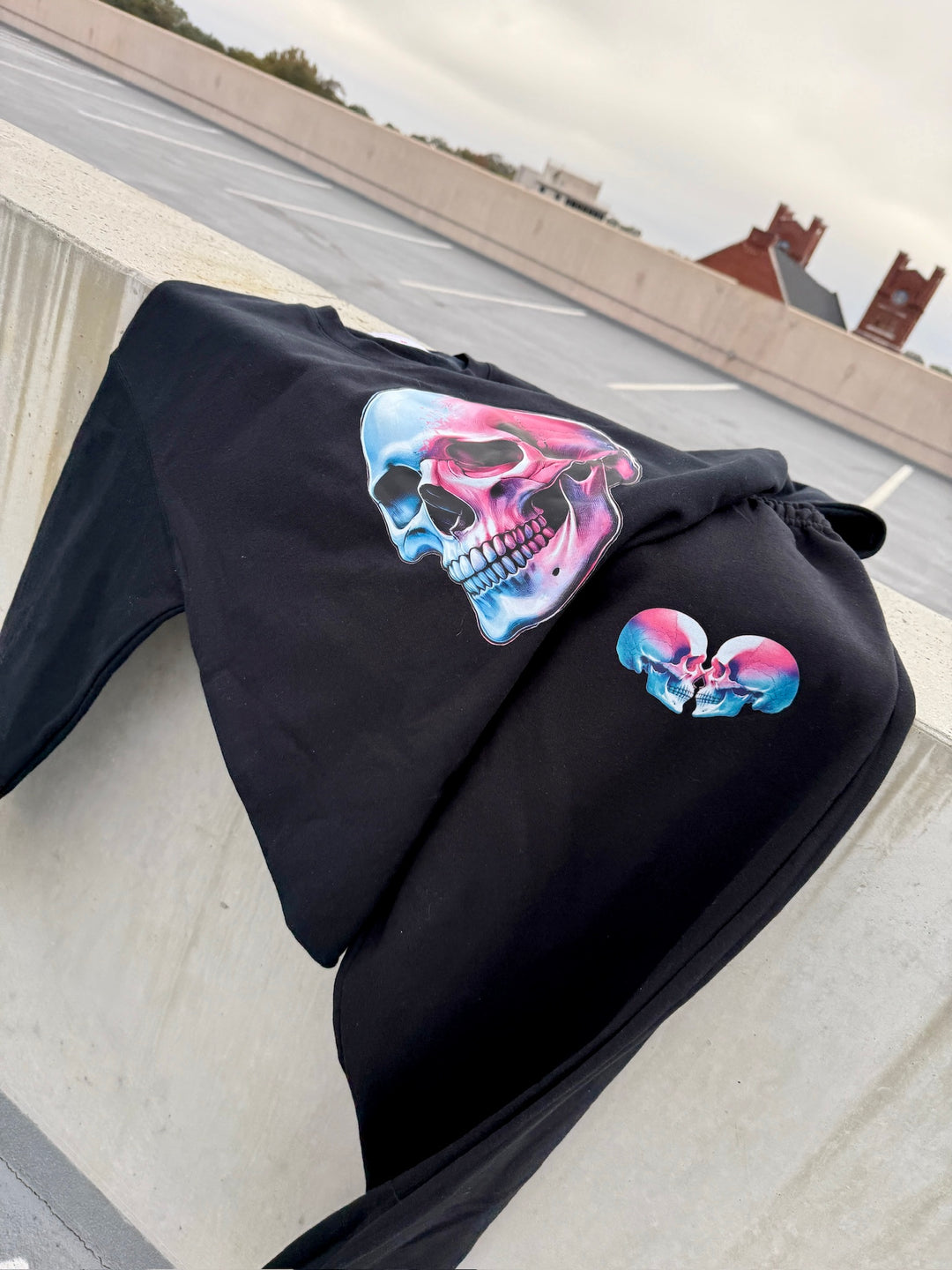 Black Super Skull Sweatshirt and matching Sweatpants with Skull Design on concrete wall