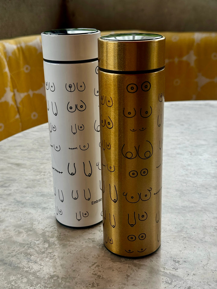 Smart water bottles in white and gold showing abstract line art of the female form representing breast reconstruction and recovery. Confidence Doc x Ladyspinedoc collaboration.