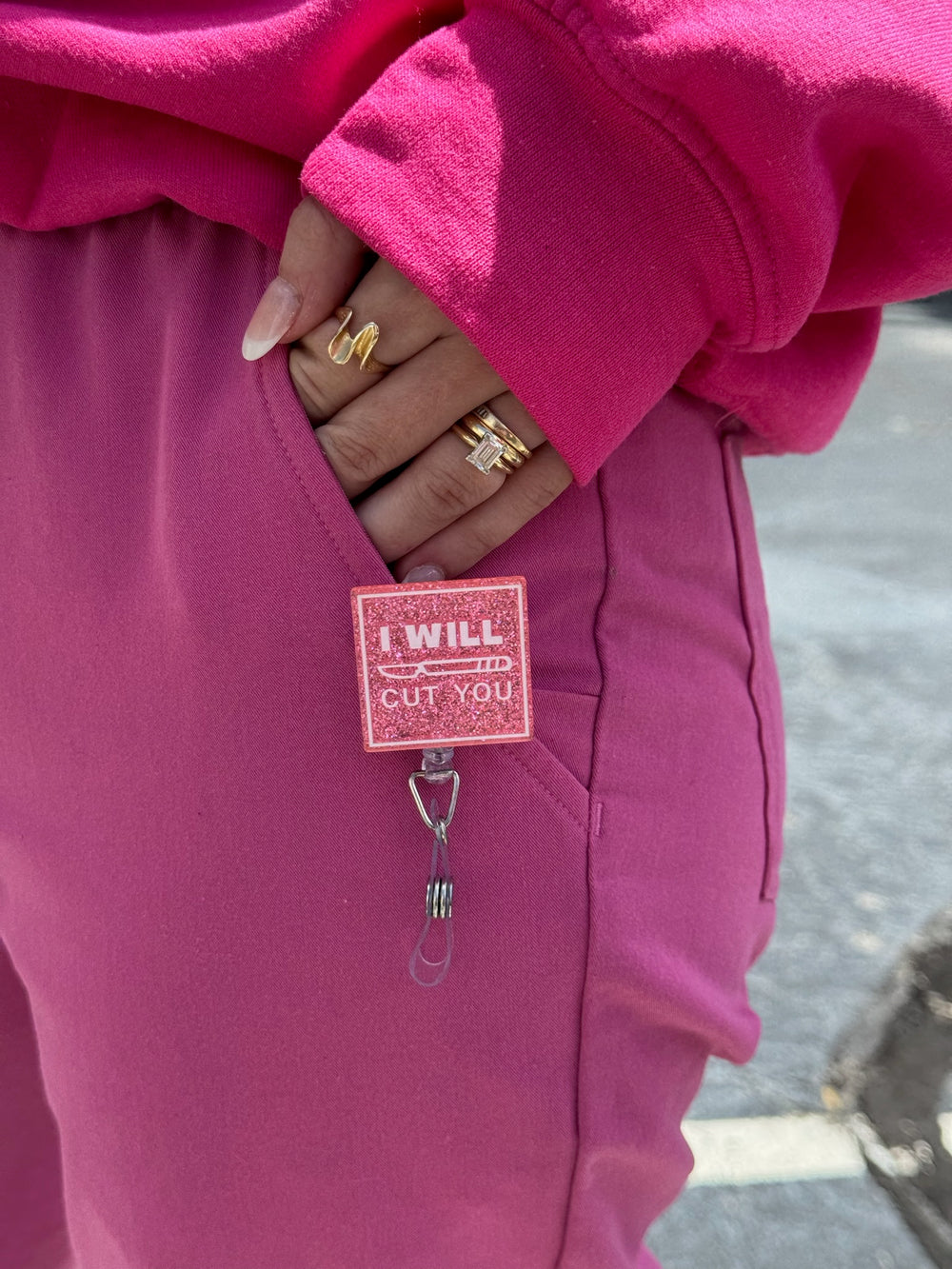 Person wearing a pink "I Will Cut You" badge reell with matching pink shirt and pink pants.