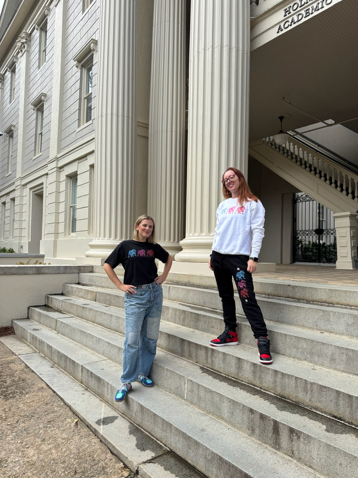 Two people standing on the steps of a classical building with columns.