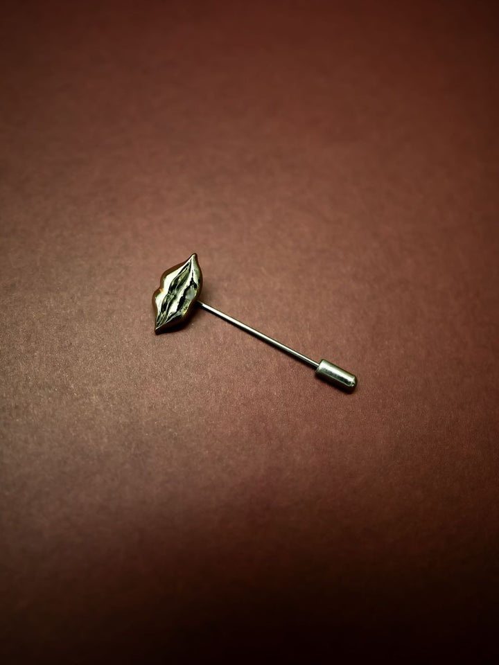 Lip-shaped lapel pin on a brown background